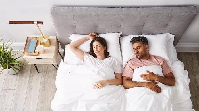 Man and woman back sleeping on grey aesthetic bed