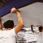 Two workers lift up Silk & Snow mattress over their head at Sleep Dream in Toronto, Ontario.