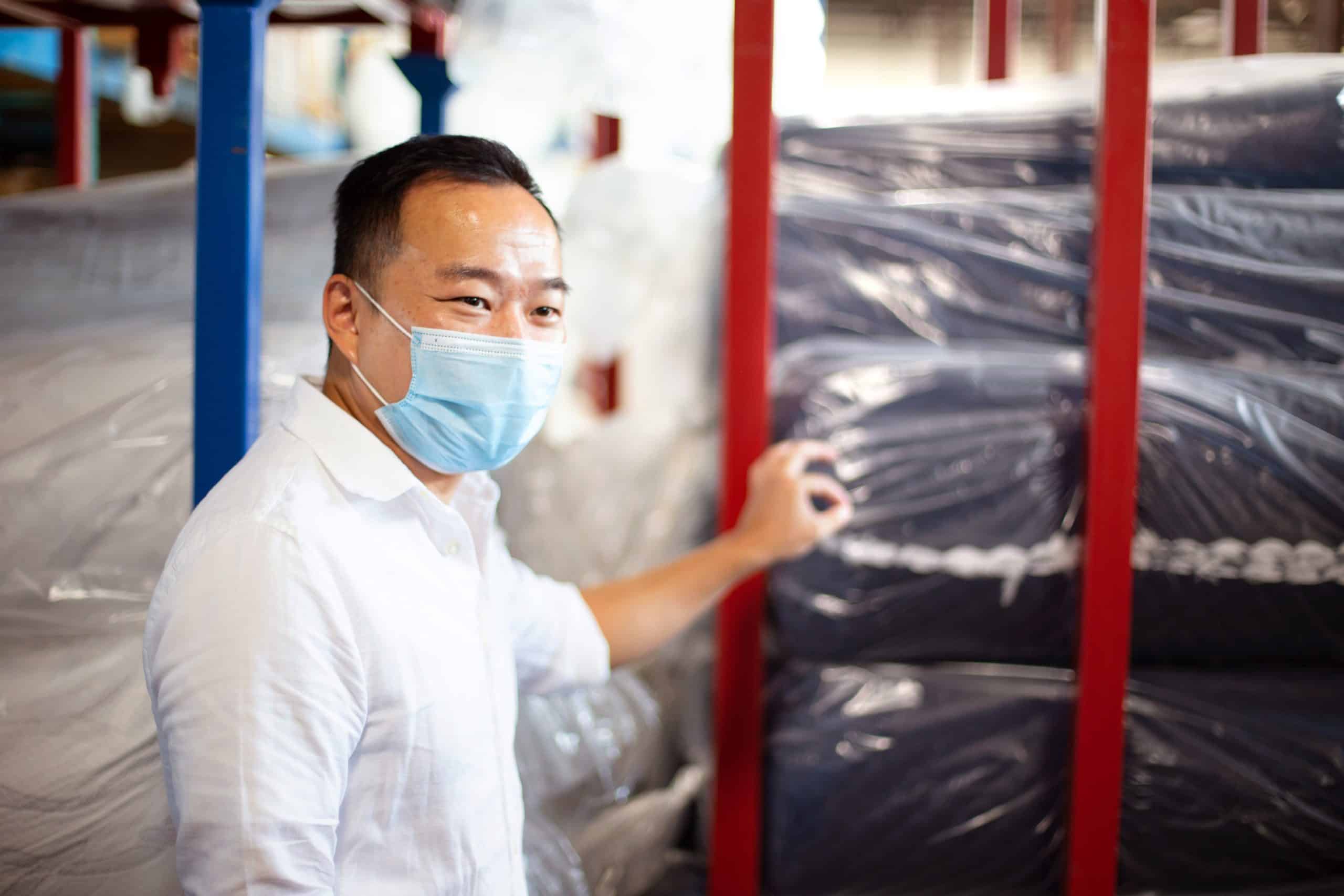 Man feels plastic packaging at Fine Cotton Factory Inc. in Toronto, Ontario.
